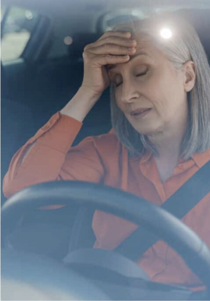Woman having a migraine wile driving. Migraines and Driving